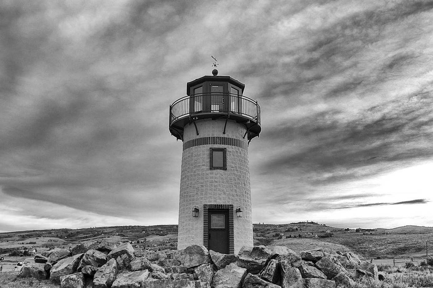 Black and white photograph of a lighthouse on a rocky shore
