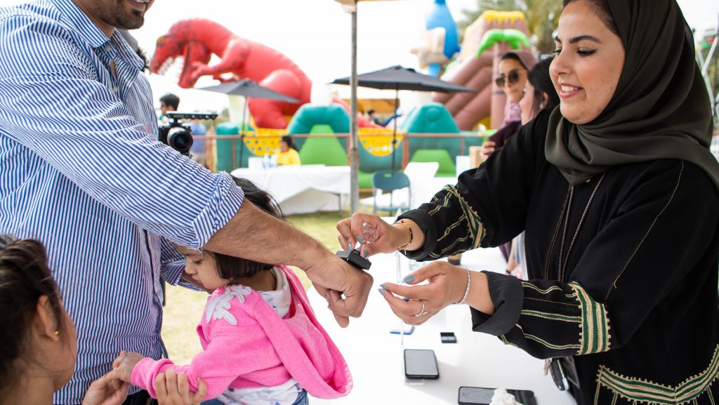 A volunteer helping children at a DGS family activity