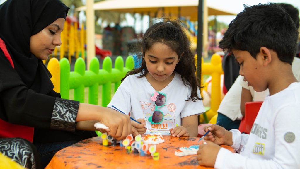 Children making crafts at a DGS family activity table